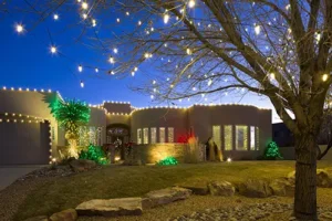 Stunning holiday lighting installation in Albuquerque featuring festive house and tree decorations with warm white and colorful LED lights.