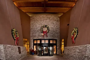 Festive commercial holiday lighting installation in Albuquerque, NM, featuring illuminated wreaths and elegant entrance decor.