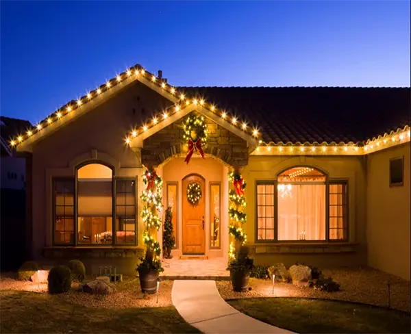 Residential home decorated with professional holiday lighting installed along the roofline and entryway